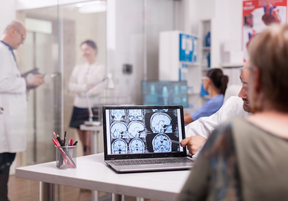 senior-woman-hospital-office-looking-brain-ct-scan-while-discussing-with-doctor-about-diagnosis-sick-young-woman-elderly-medic-with-grey-hair-clinic-corridor